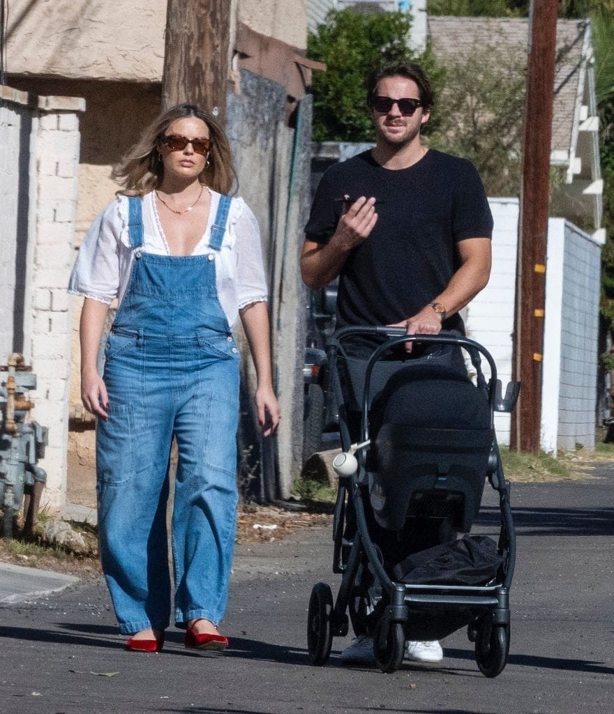 Plano medio de Margot Robbie y Tom Ackerley paseando con su bebé