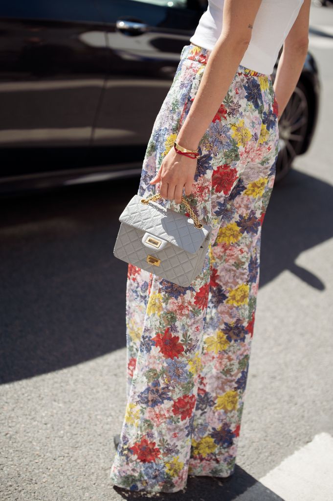 PARÍS, FRANCIA - 25 DE JUNIO: Lisa Hahnbuck lleva pantalones anchos con flores, camiseta blanca de tirantes y bolso azul polvo de Chanel fuera del desfile de Chanel durante la Alta Costura Otoño/Invierno 2024/2025 como parte de la Semana de la Moda de París el 25 de junio de 2024 en París, Francia. (Foto de Raimonda Kulikauskiene/Getty Images)