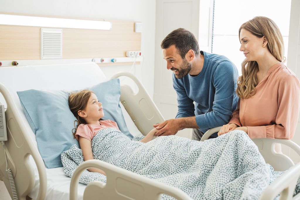 Niña en el hospital con sus padres