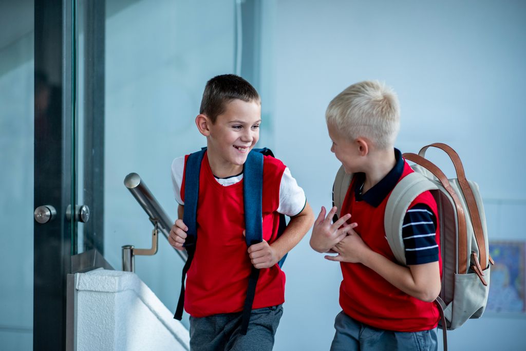 dos niños con la mochila, camino del colegio