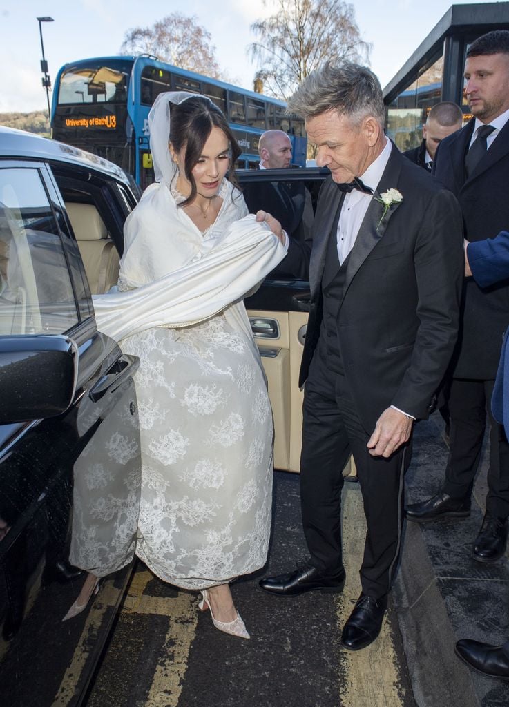 Holly, hija del chef famoso Gordon Ramsay, llegó a la histórica iglesia acompañada por su padre, vistiendo un vestido de satén fluido con detalles de encaje y una dramática capa color marfil. 