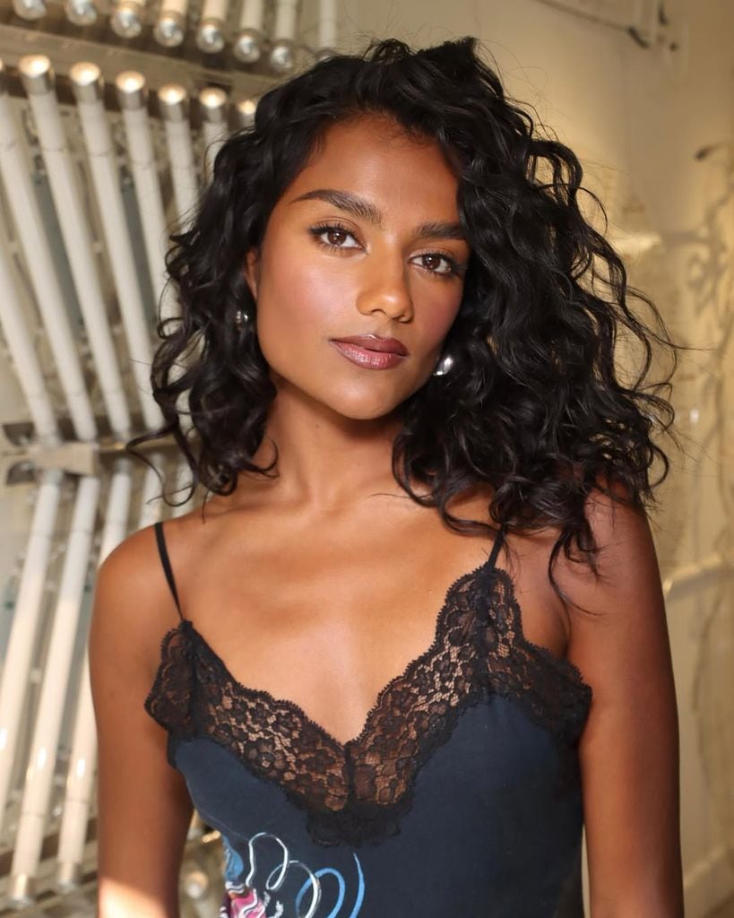 Simone Ashley posando con su maquillaje con tono melocotón y naranja que iluminan su piel