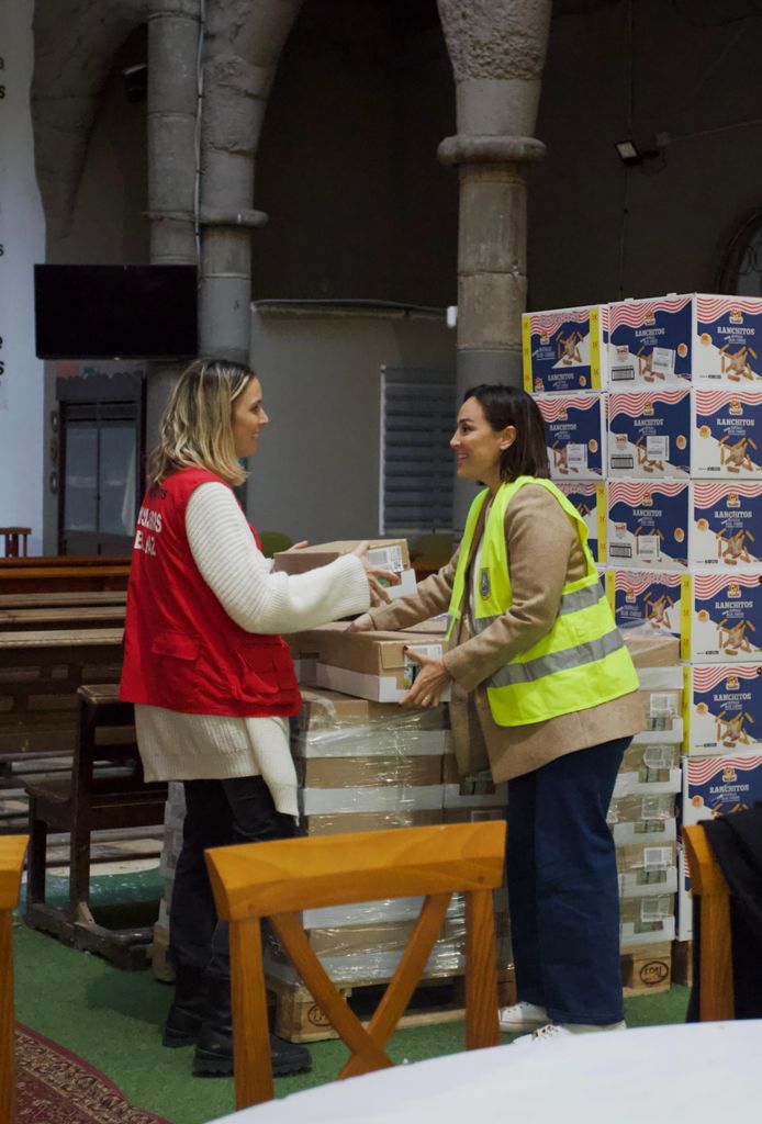 Plano medio de Tamara Falcó colaborando con la carga de un camión de alimentos
