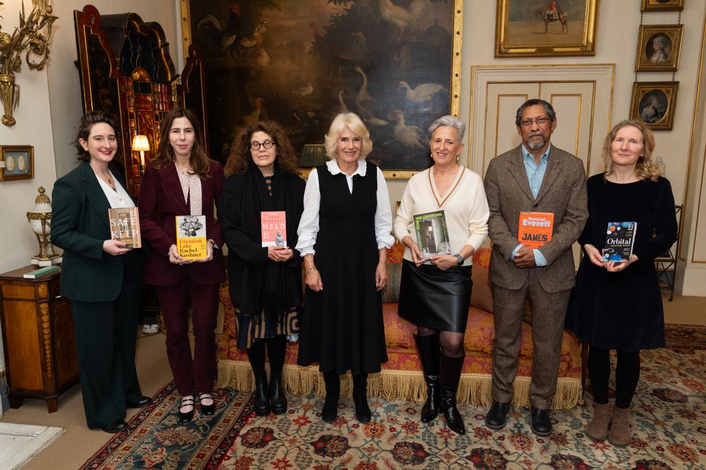 Plano medio de la reina Camilla posando con algunos escritores 