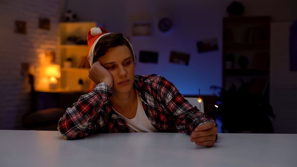 Adolescente solo en su dormitorio en Navidad