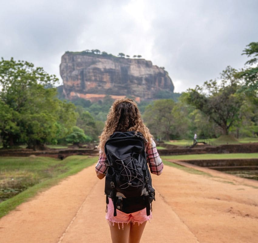 Mujer mochilera caminando hacia el templo de la roca de Sigiriya en Sri Lanka