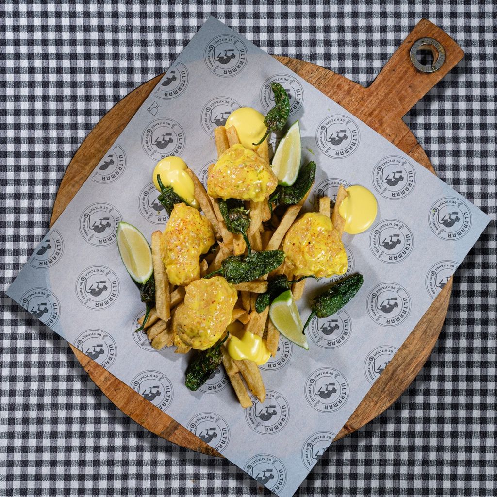 Merluza frita en piel de lima, patatas fritas y padrones