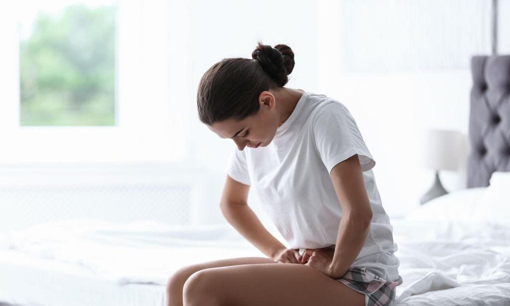 mujer con dolores en la tripa