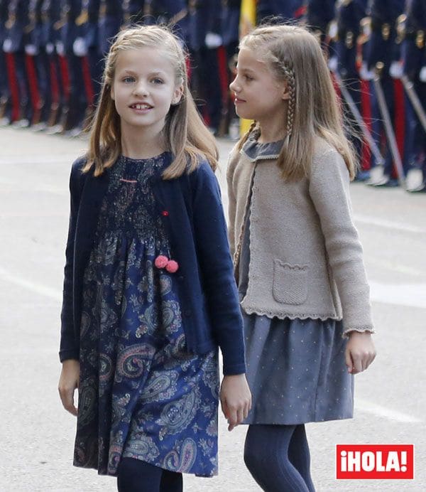 La princesa de Asturias y la infanta Sofía, que iban peinadas igual con trenzas de raíz, lucían vestidos del mismo estilo en diferentes tonos de la firma Nanos
