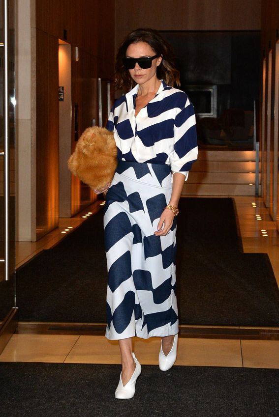 Victoria Beckham con vestido bicolor y zapatos blancos