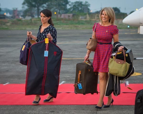 Sophie Agnew, asistenta de la secretaria de la Duquesa de Cambridge, y Natasha Archer, estilista, bajan del avión muy cargadas en el aeropuerto Tezpur de Assam
