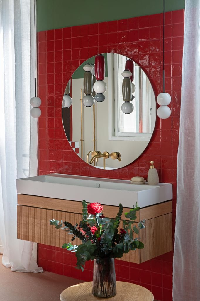 Baño con pared de azulejos rojos