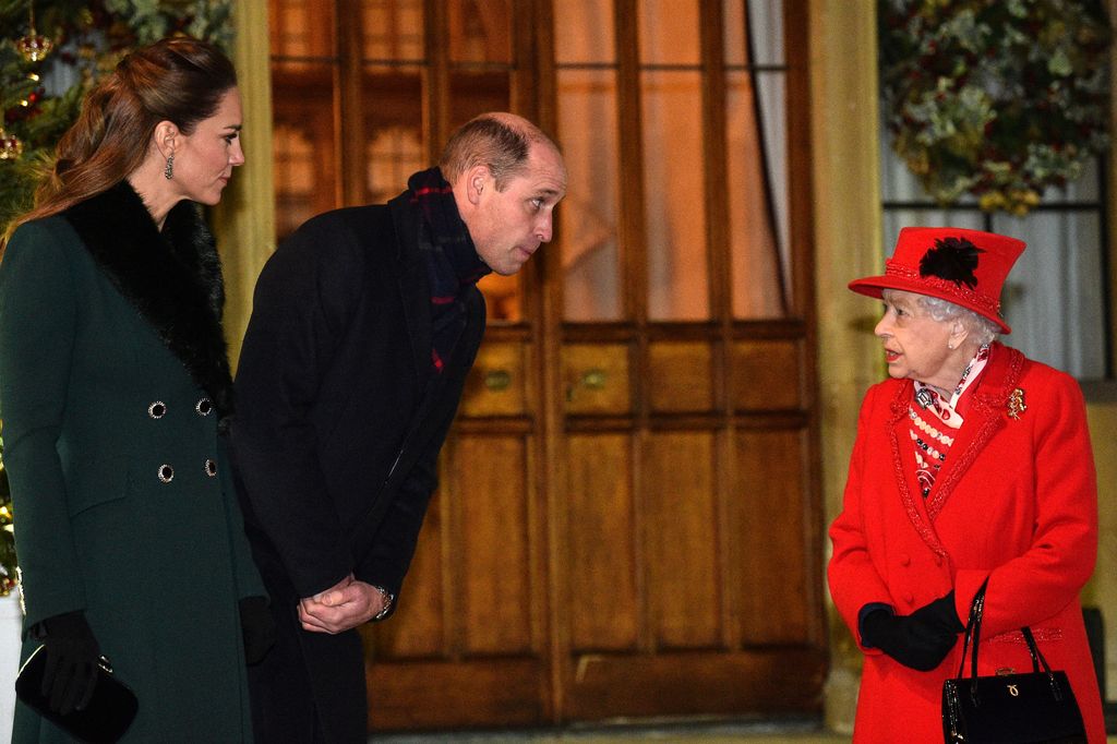 Plano medio de Guillermo de Inglaterra y Kate Middleton conversando con Isabel II
