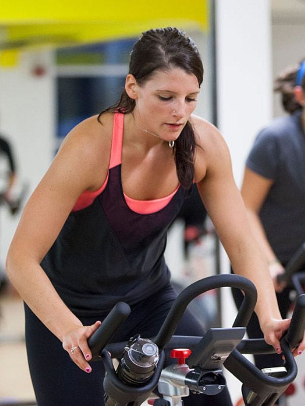 Mujer pedalea en bici fija