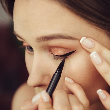 mujer aplica delineador de ojos