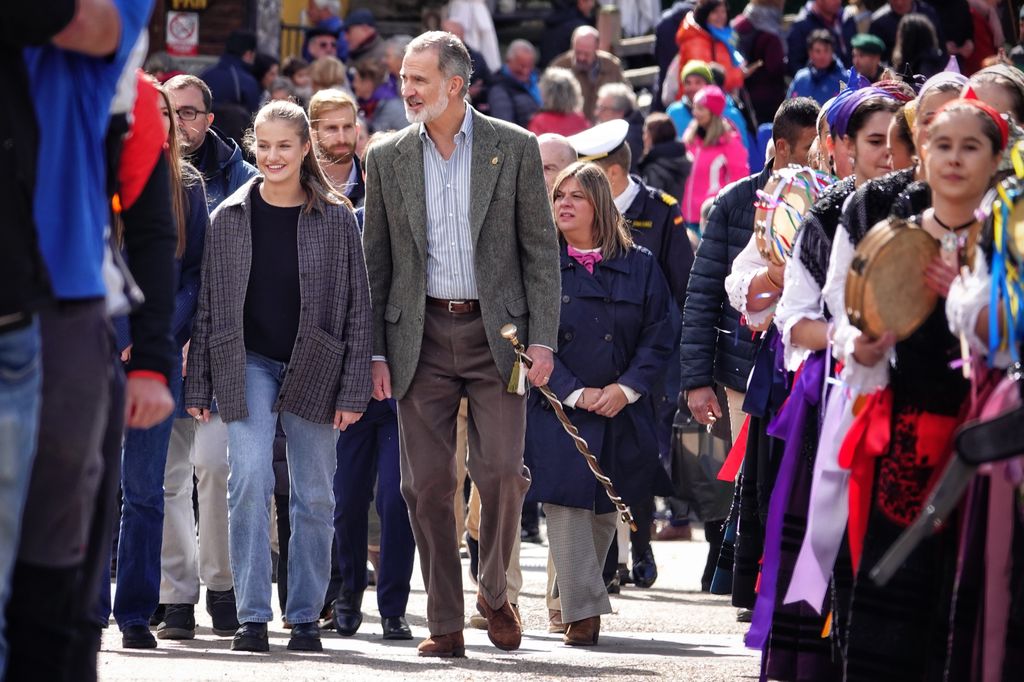 Plano entero de la princesa Leonor y el rey Felipe caminando por Sotres durante un desfile popular
