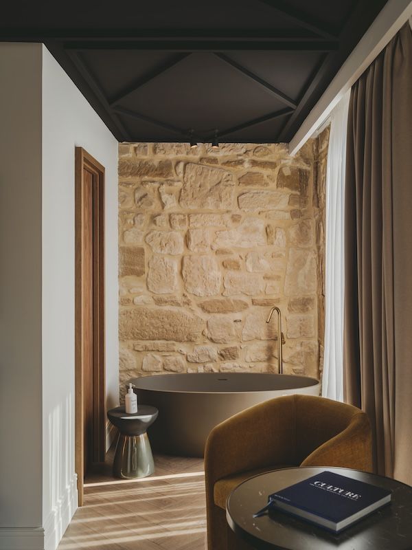 Suite con pared de piedra y suelo de madera