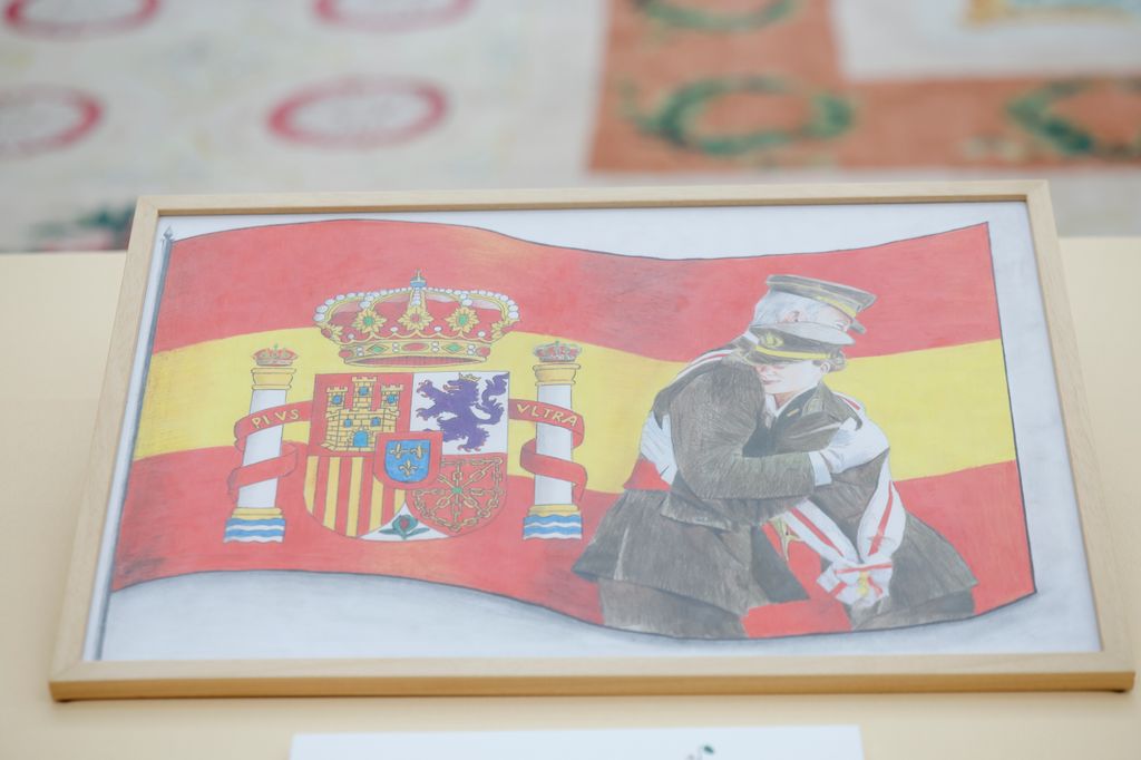 Imagen de don Felipe y doña Letizia vestidos de militar con la bandera de España 