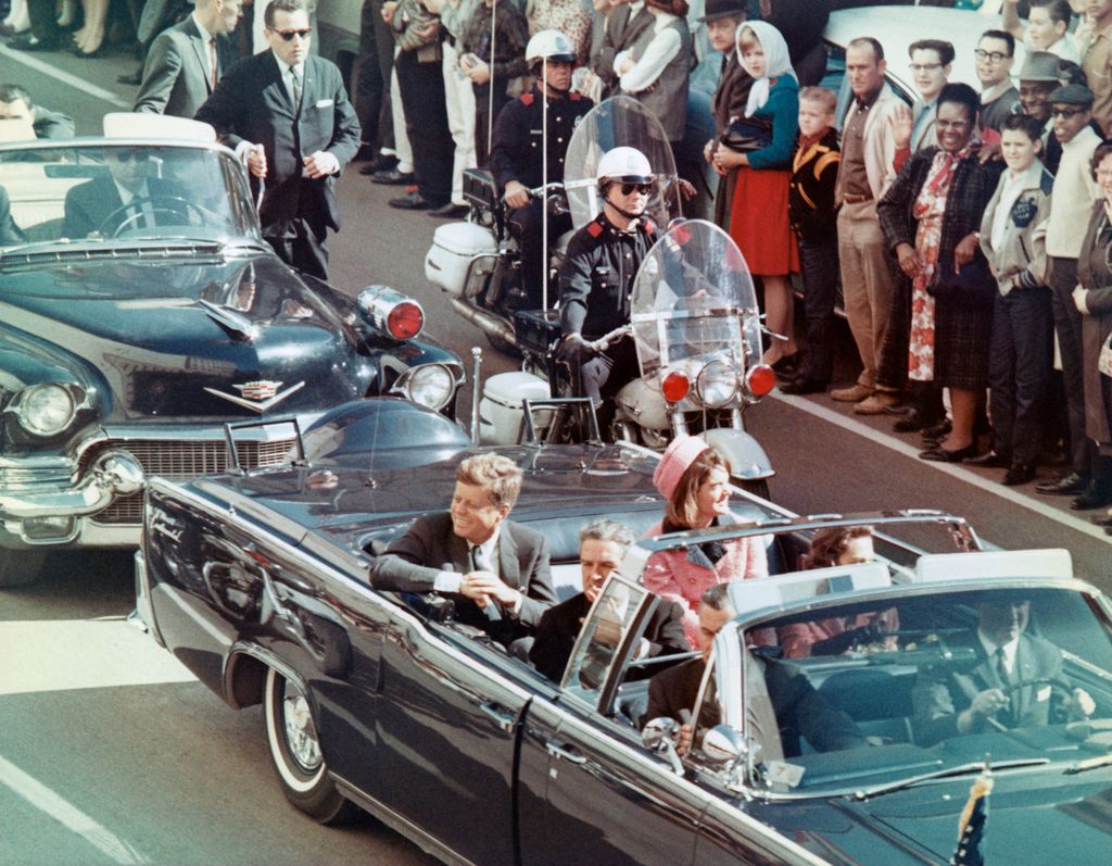 John F. Kennedy y Jacqueline Kennedy saludan sonrientes a la multitud durante su recorrido en coche por Dallas el 22 de noviembre de 1963, apenas unos minutos antes del asesinato que conmocionó al mundo
