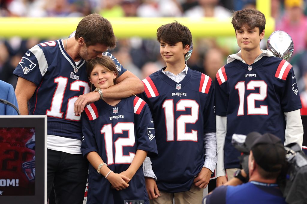 Plano medio de Tom Brady dando un beso a su hija con sus hijos al lado