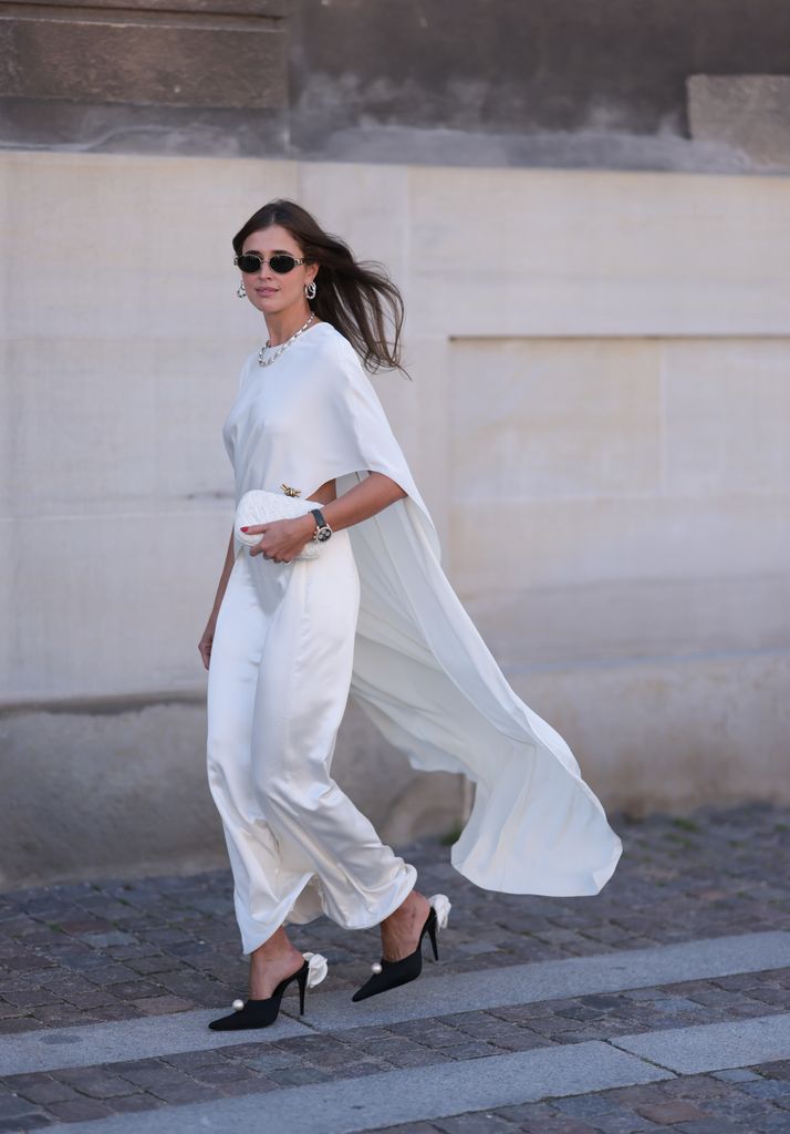 Darja Barannik fue vista llevando un vestido largo de satén blanco. También llevaba zapatos negros de tacón con una flor blanca y una perla blanca, pendientes de perlas, un collar de perlas y gafas de sol negras de Celine, antes del desfile de Lovechild 1979 durante el segundo día de la Semana de la Moda de Copenhague (CPHFW) Primavera/Verano 2025 el 6 de agosto de 2024 en Copenhague, Dinamarca.