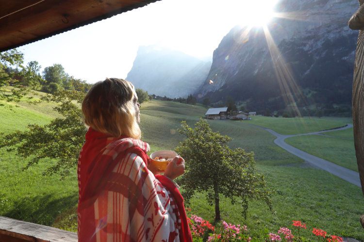 Mujer disfrutando de una vista de la montaña mientras se toma un bol de frutas