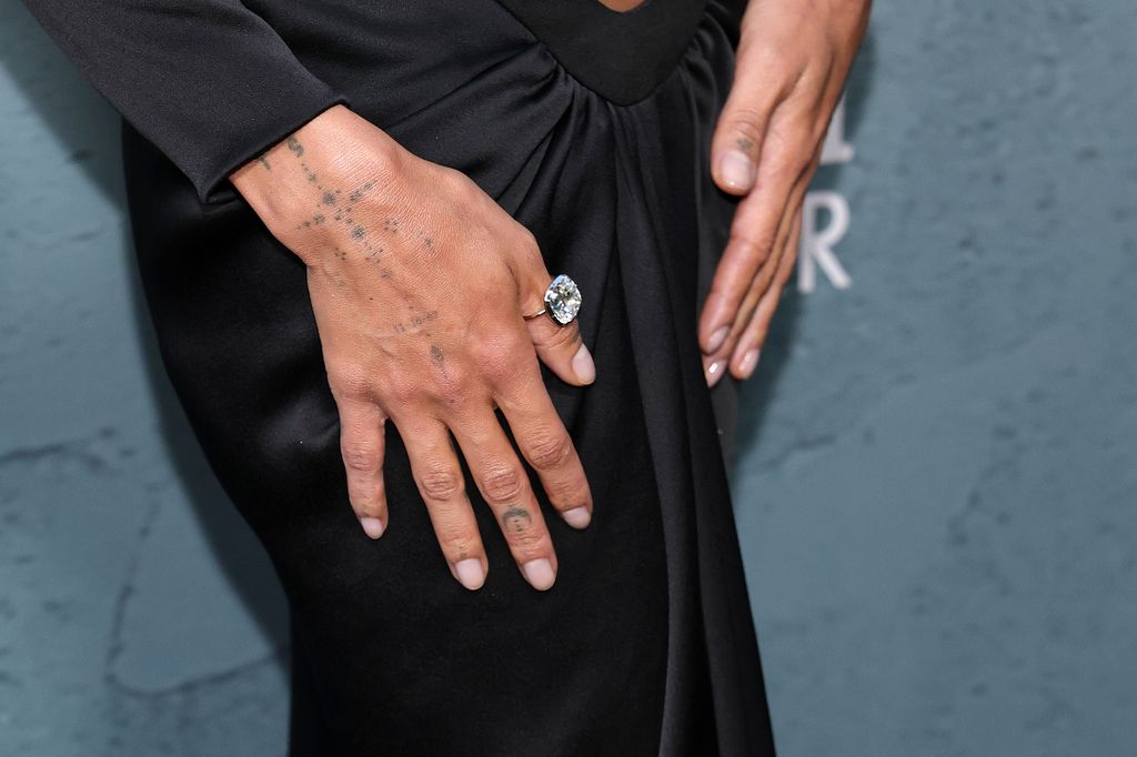 La actriz lleva un anillo con un diamante con corte cojín solitario en el dedo pulgar.