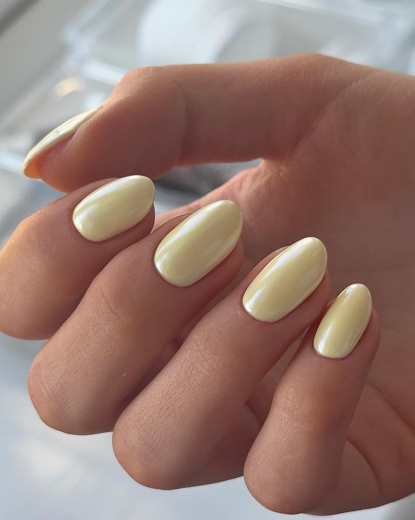 Manicura en amarillo mantequilla con efecto espejo