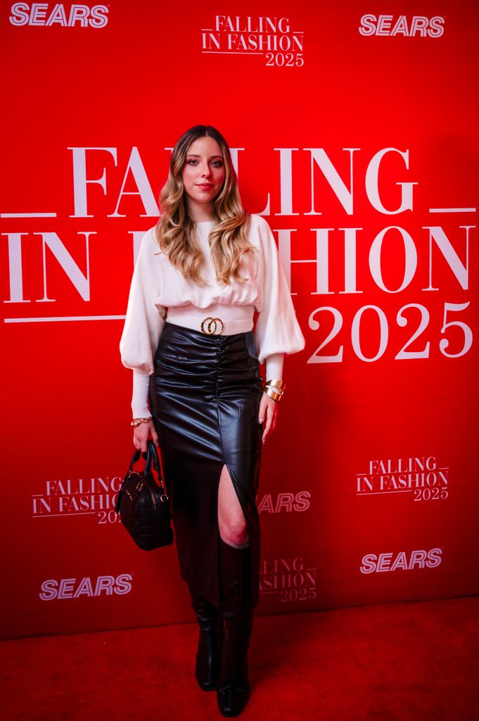 Estef Coppola en un look de falda negra de cuero, suéter blanco y botas XL. 