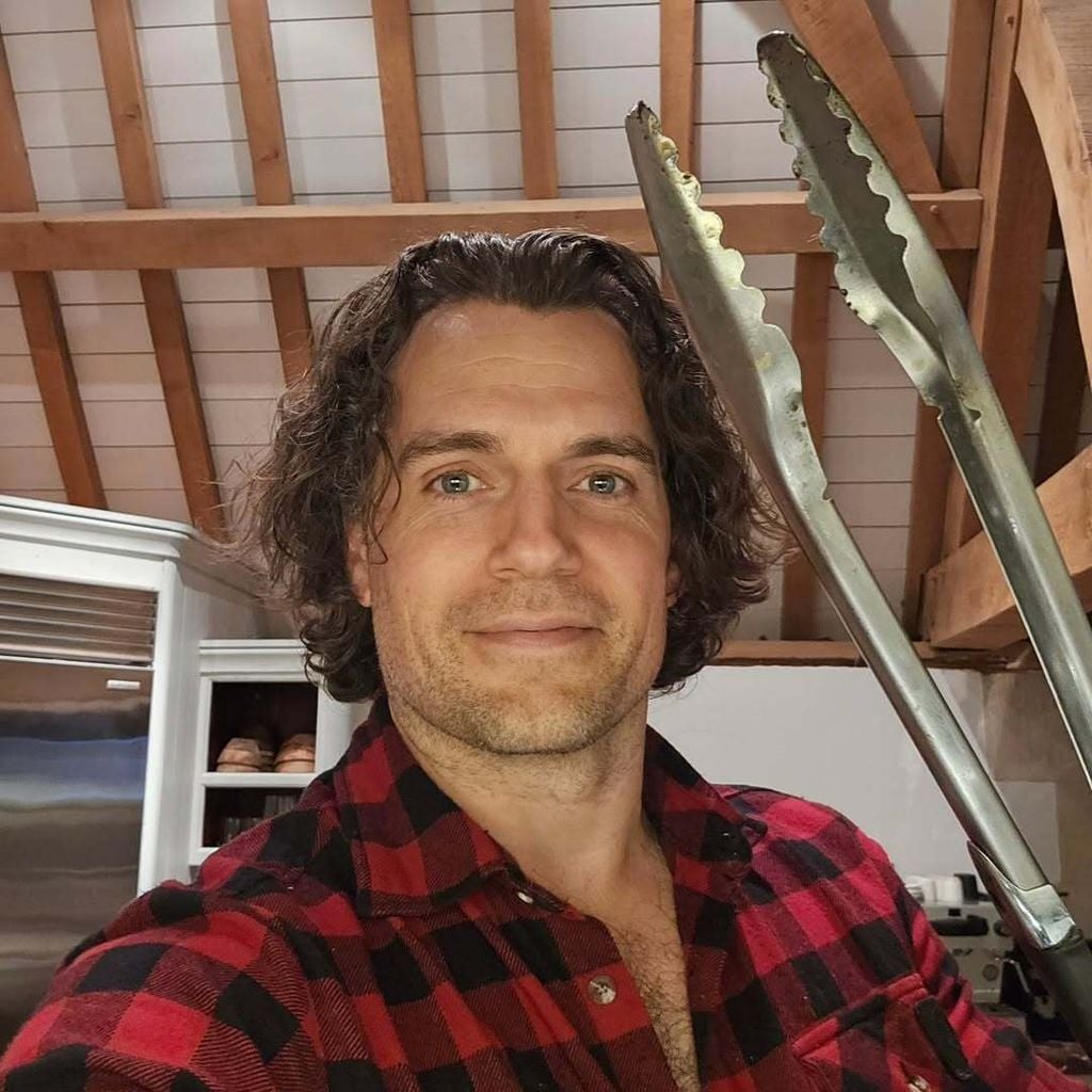 Henry Cavill cocinando en su casa, pinzas de carne en mano.
