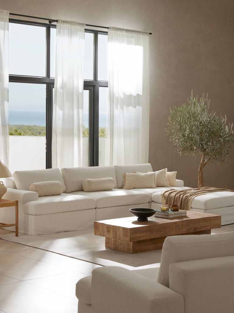 Salón con sofá y visillos blancos