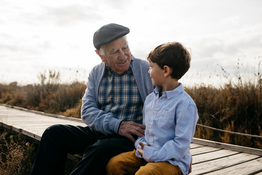abuelo y nieto sentados al aire libre