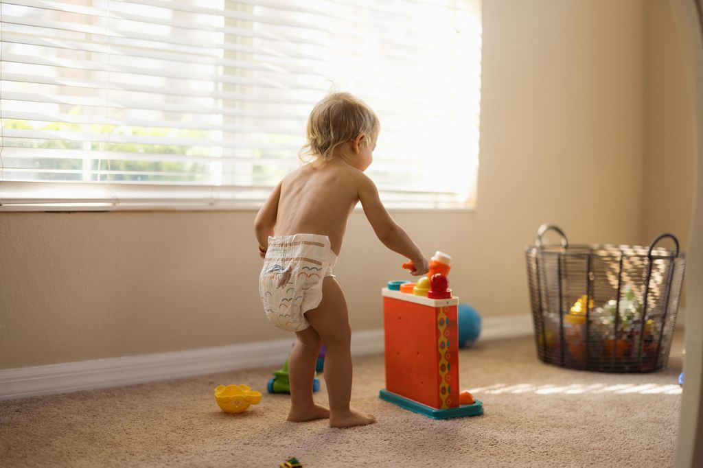 Niño con pañal jugando en casa