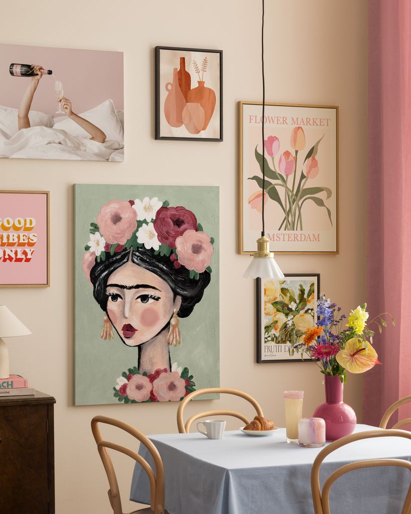 Pared decorada con composición de láminas en tonos rosas