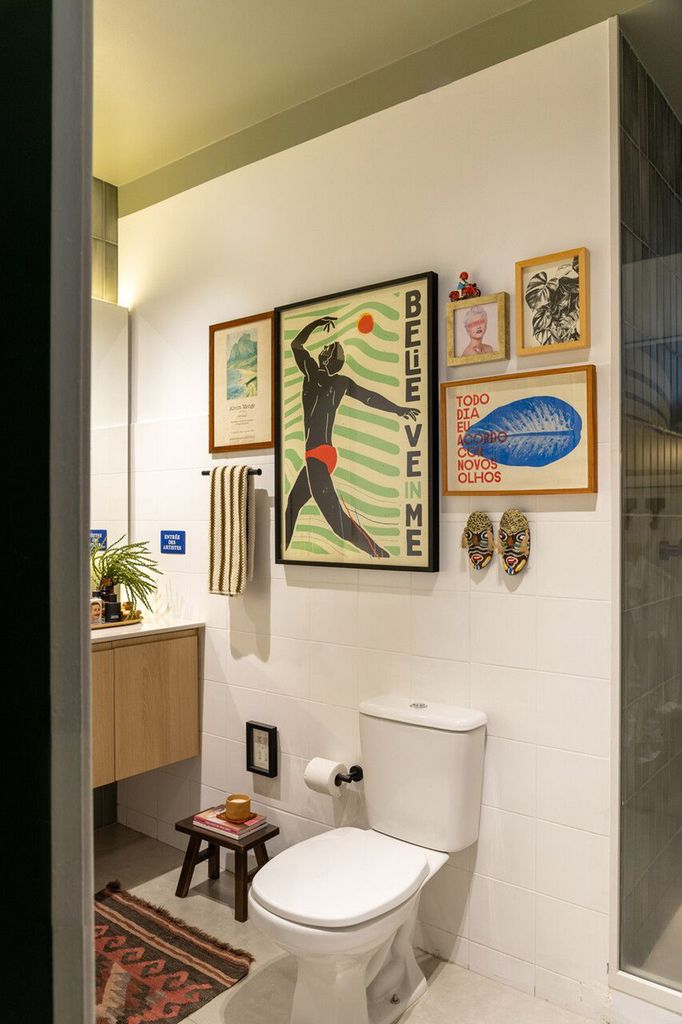 Pared del baño decorada con obras de arte