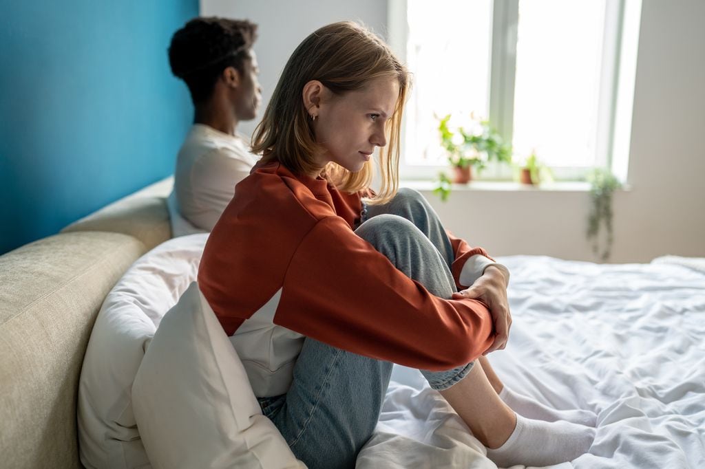 pareja enfadada y triste, sentada en la cama