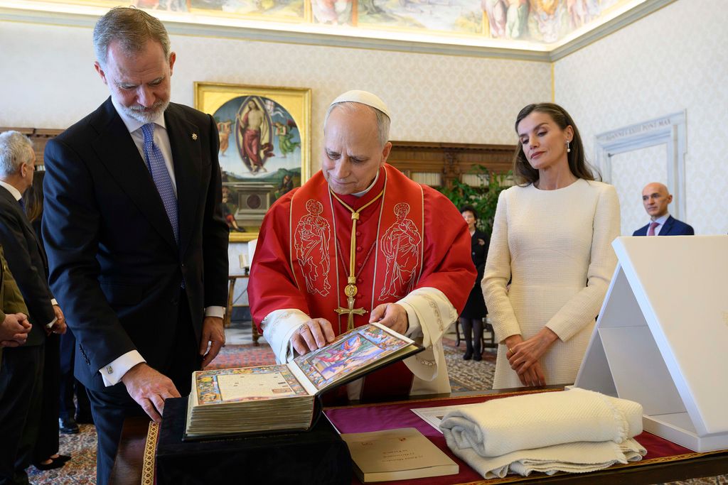 El Papa observa el facsímil que le han regalado los Reyes