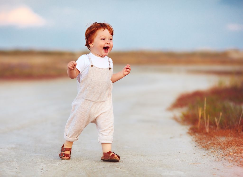 Niño pequeño caminando con sandalias en el exterior en verano