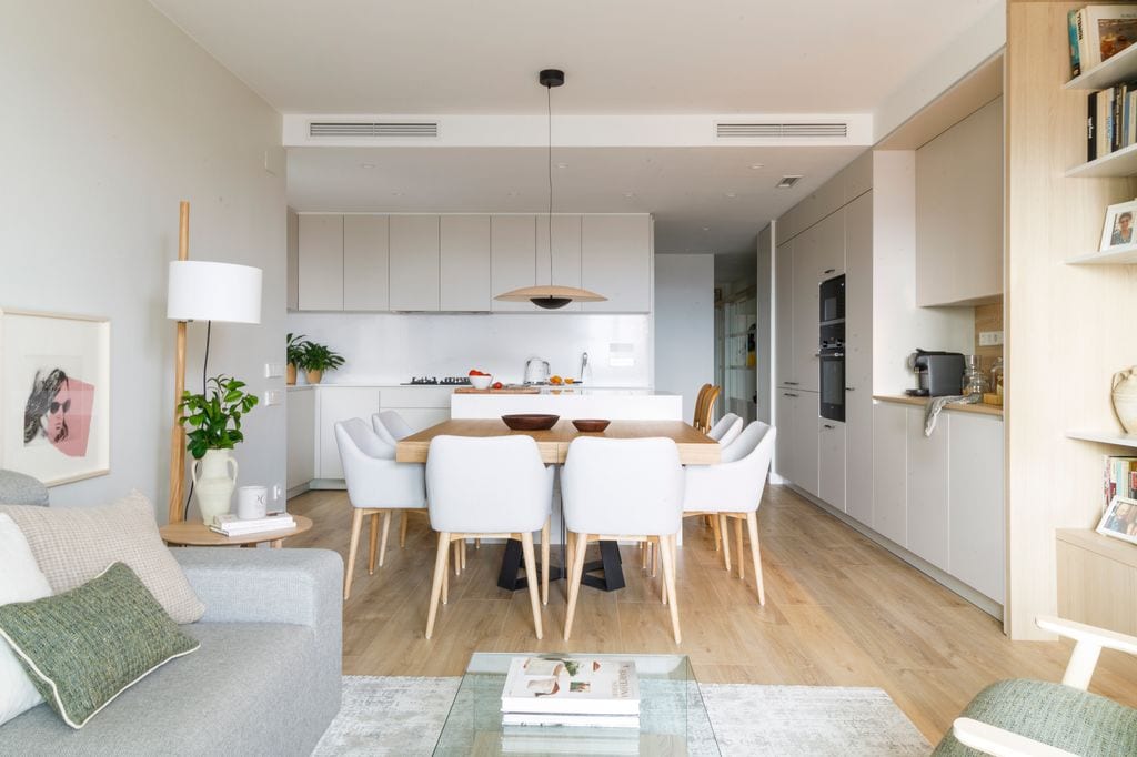 Comedor con mesa de madera cuadrada y sillones blancos