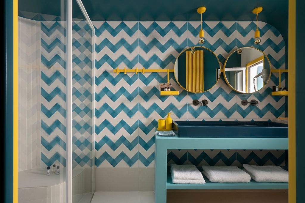 Baño con base neutra y los colores azul y amarillo como grandes protagonistas