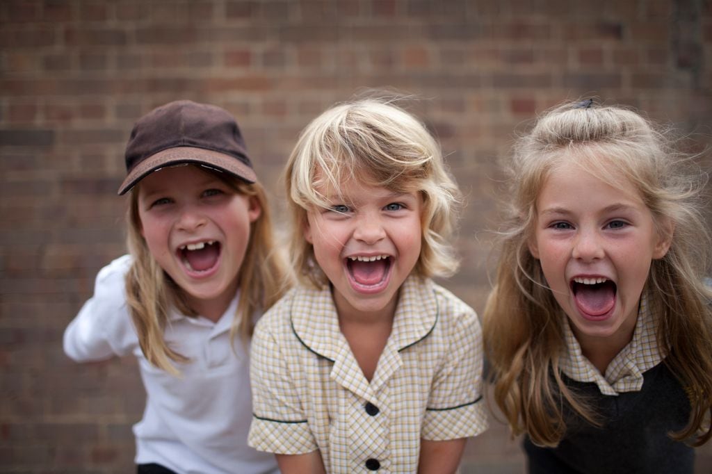 Amigos jugando y sonriendo en primer plano en el patio del colegio
