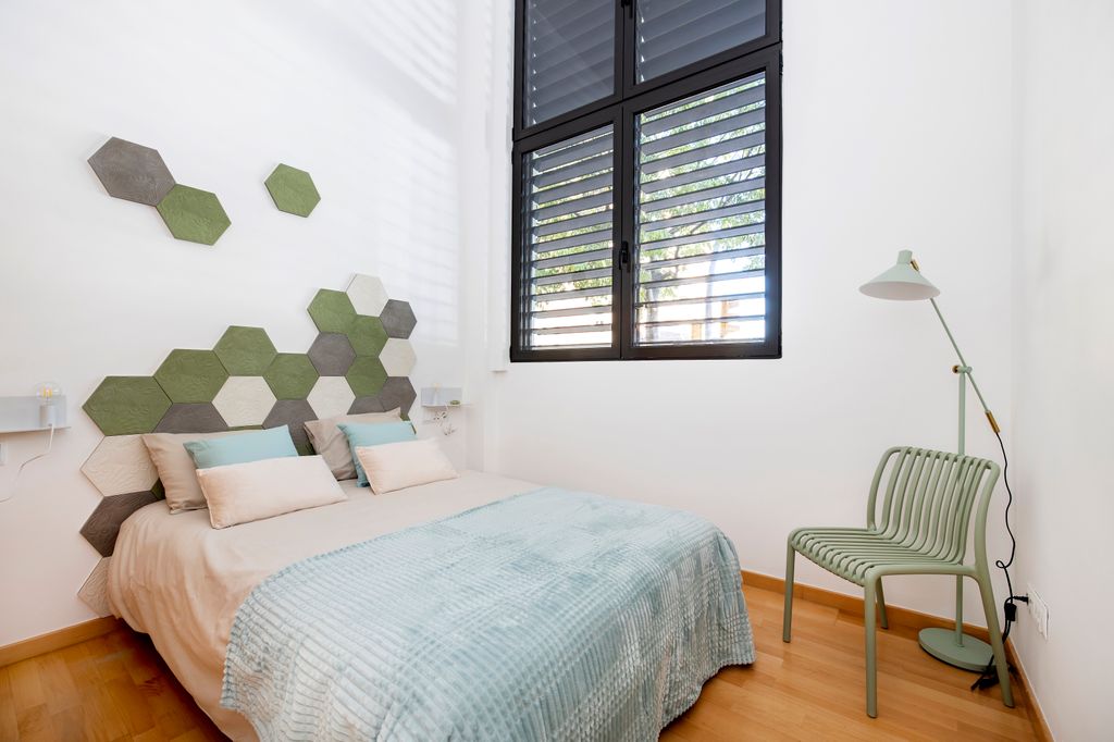 Interiorismo emocional en un dormitorio ideado por Esther Algara con un cabecero con las baldosas hexagonal que Antoni Gaudí diseñó en 1904, un ‘panot’ muy querido por los barceloneses