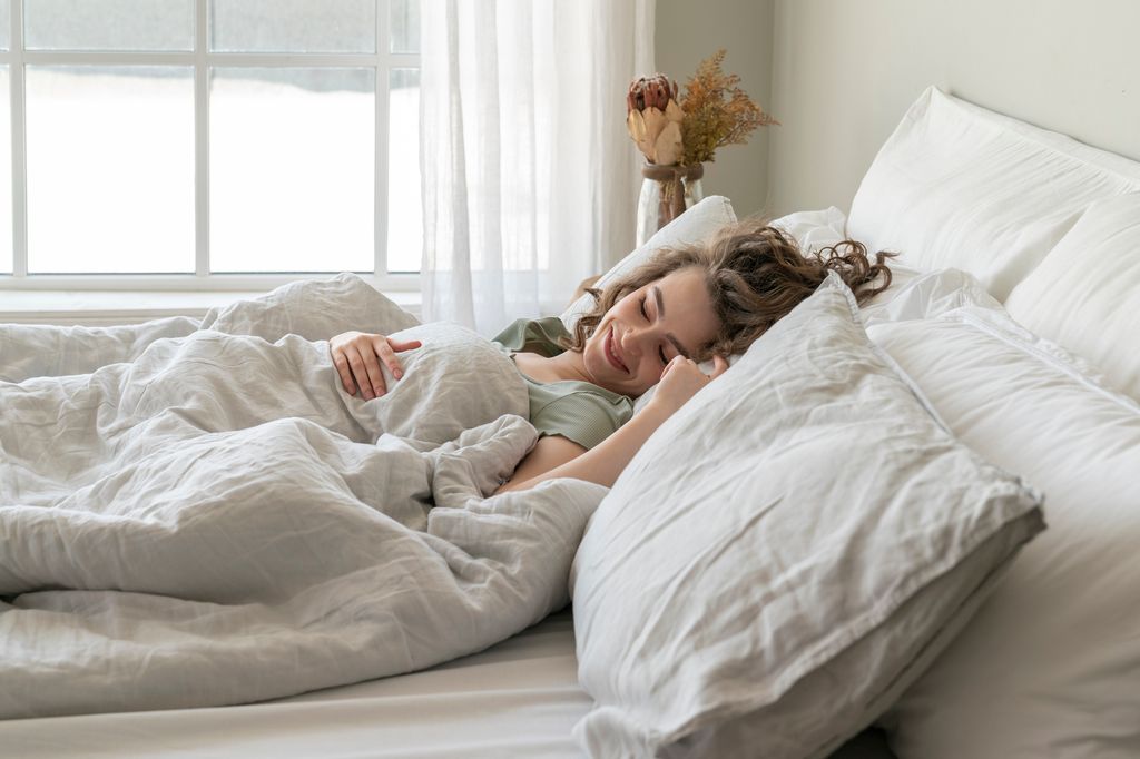 mujer sonriente tumbada en la cama