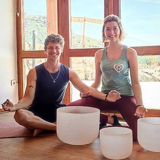 Plano medio de Nicolás Coronado haciendo yoga con su pareja Natalia Moreno