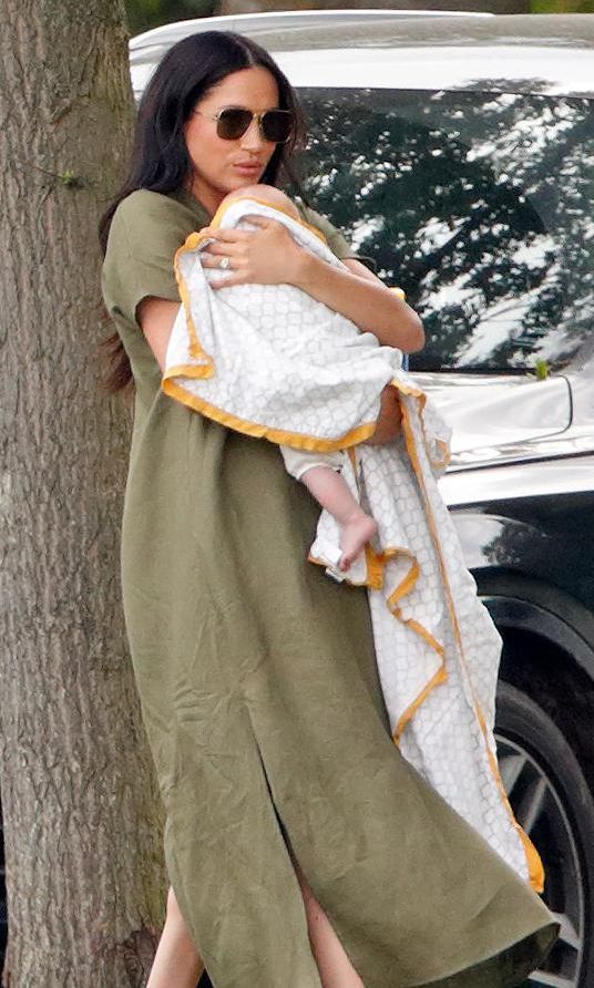 meghan markle con vestido color khaki acunando al baby archie