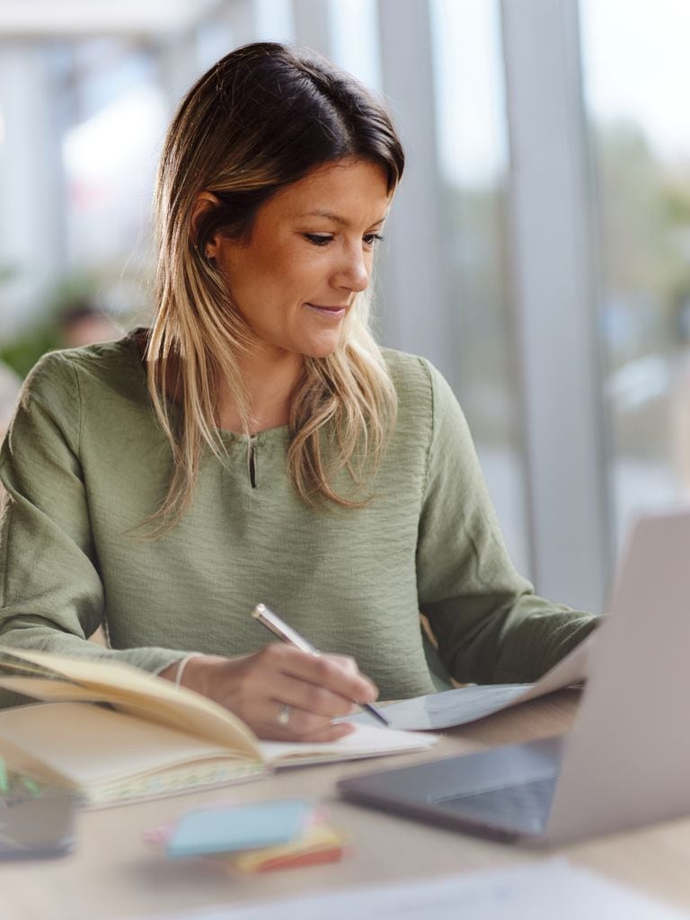 Mujer con jersey verde escribiendo