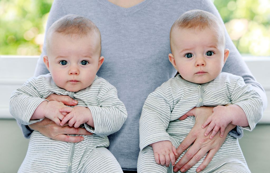 madre con dos bebés gemelos en sus brazos