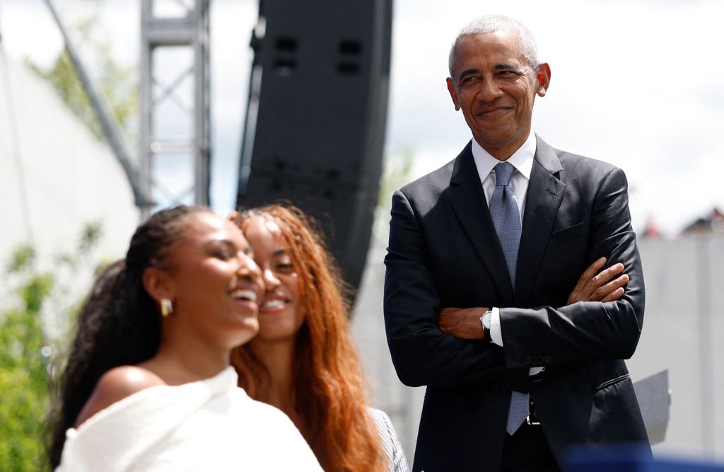 Barack Obama, sonriente al ver una interacción de sus hijas