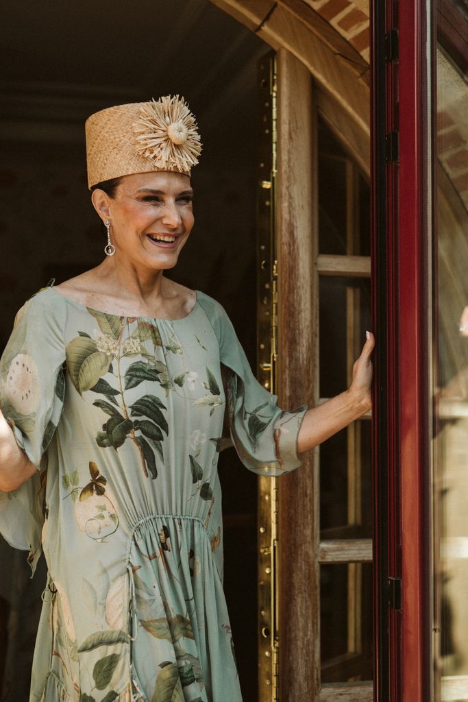 Madrina de boda con look vaporoso de Colima y sombrero con flor
