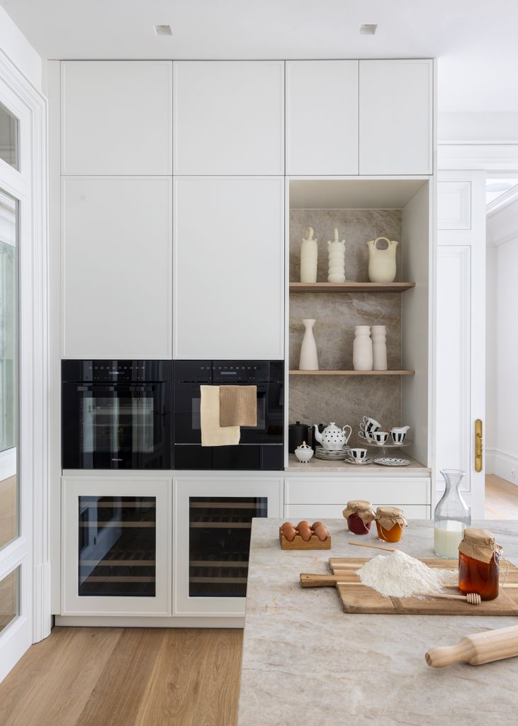 Cocina con muebles blancos y electrodomésticos negros